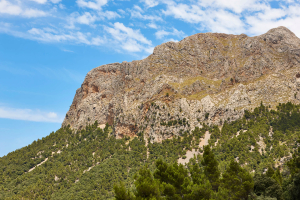 Bergspitze eines Felsens in der Serra de Tramuntana auf Mallorca vor blauem Himmel.
