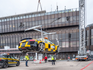 Das Follow-me-Fahrzeug Audi R8 hängt am Kran und schwebt noch 2 Meter über dem Boden.