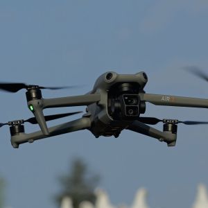 Fliegende Drohne mit Wärmebildkamera vor blauem Himmel