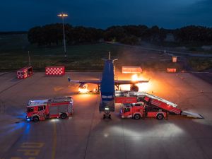 Brandsimulationsanlage und Feuerwehrautos bei Nacht