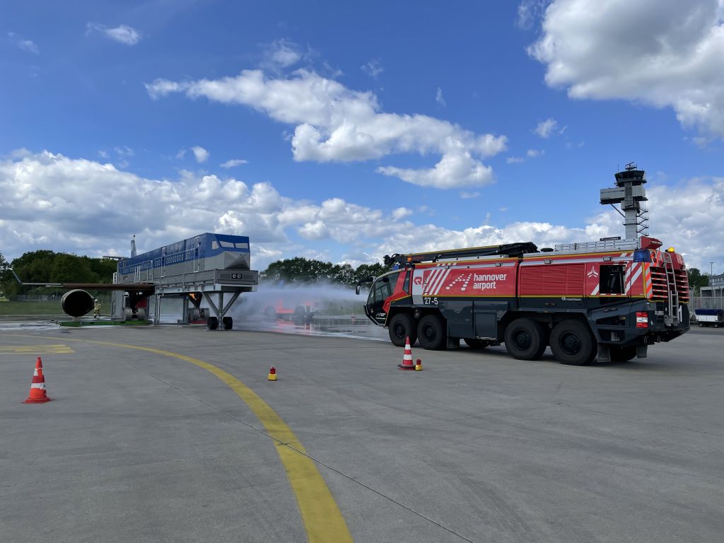 Flugfeldlöschfahrzeug greift frontal an der Brandsimulationsanlage an.