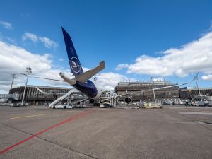 Ein Flugzeug der Lufthansa wird am Hannover Airport ent- und beladen. Man blickt von hinten auf das Flugzeug, dass am Terminal steht.