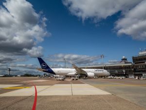 Die Lufthansamaschine A350 steht auf dem Vorfeld auf der Position 5A. Weit im Hintergrund sieht man den Tower der DFS.