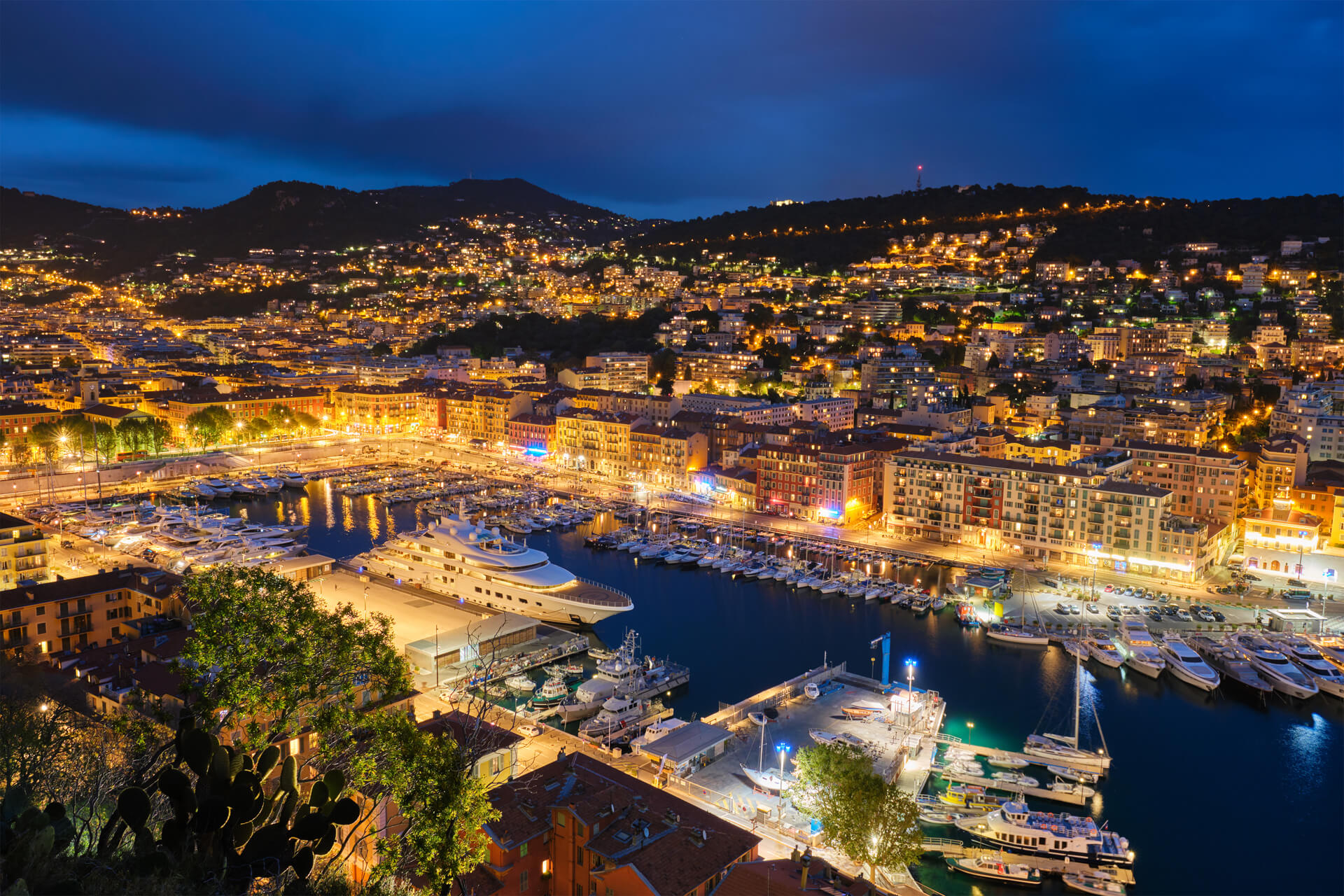 Luftaufnahme mit Blick auf Nizza und den Hafen bei Nacht mit Beleuchtung